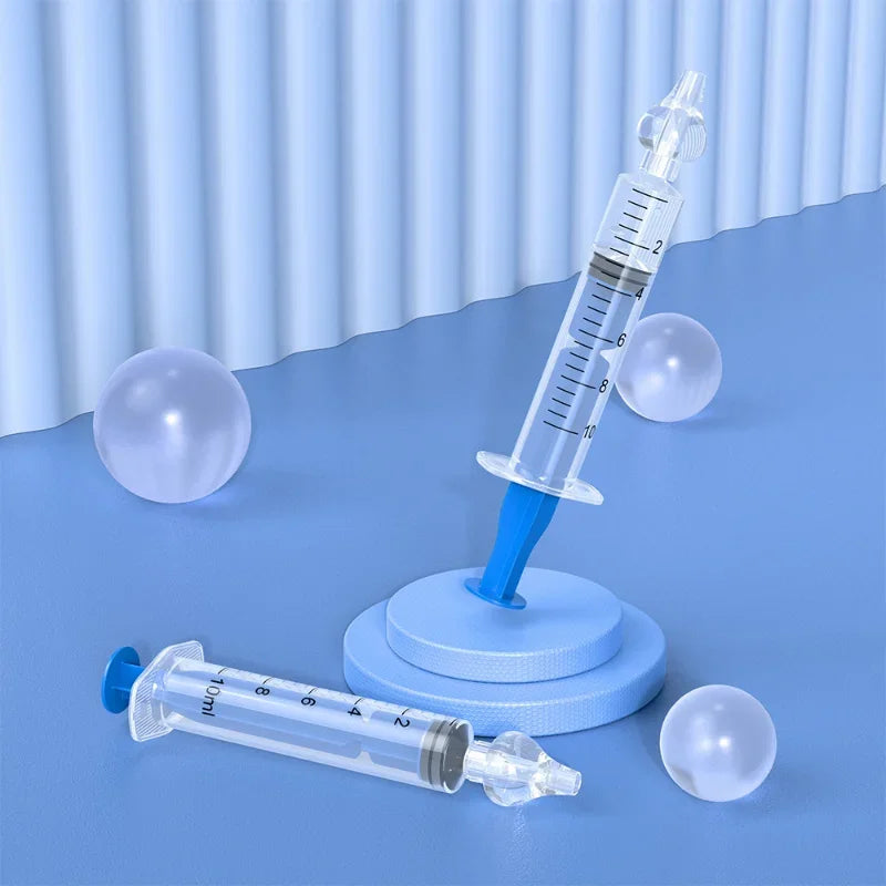 Two syringes on a blue surface with a light blue curtain background