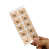 Sheet of adhesive patches held by a hand on a white background