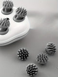 Gray silicone scrubber heads on a white base with additional scrubber heads scattered on a gray surface.