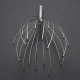 Metal head massager on a dark gray background