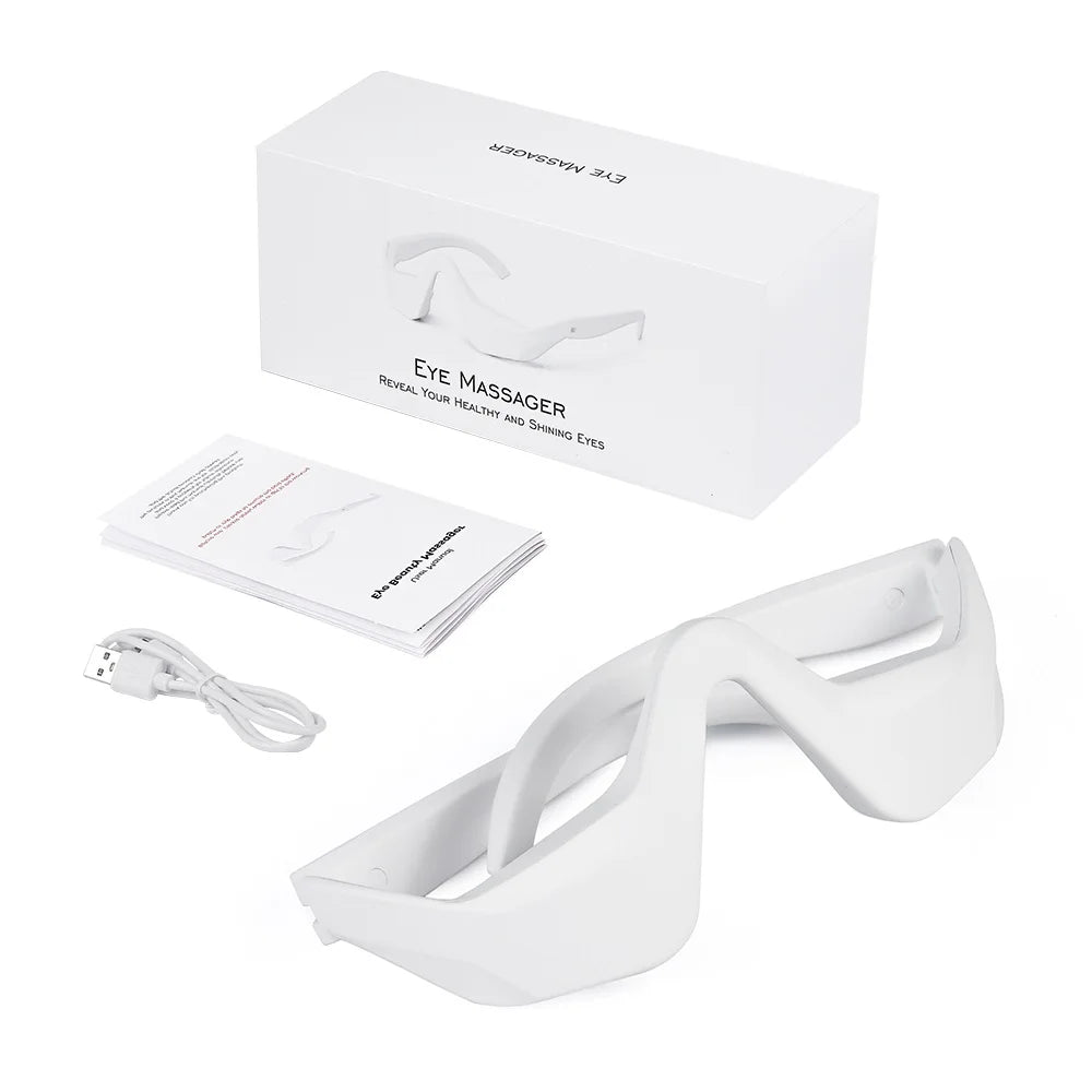 White eye massager with packaging, user manual, and USB cable on a white background